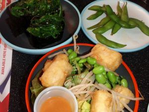 Edamamea japanilaisessa ravintolassa. Ylhäällä oikealla edamamet, alhallaa inarisushia ja salaattia, jossa on edamame-papuja ja ylhäällä vasemmalla merileväsushia. 