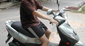 Turisti ja skootteri. Tämän mopon alle jäin, kun yritin sillä ajaa Langawilla. 