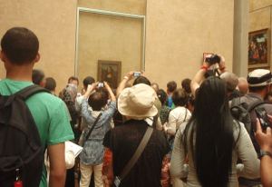 Turisteja valokuvaamasssa Mona Lisaa. 