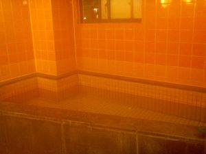 Kapselihotellin kylpyosaston höyryvä kuumavesiallas. 