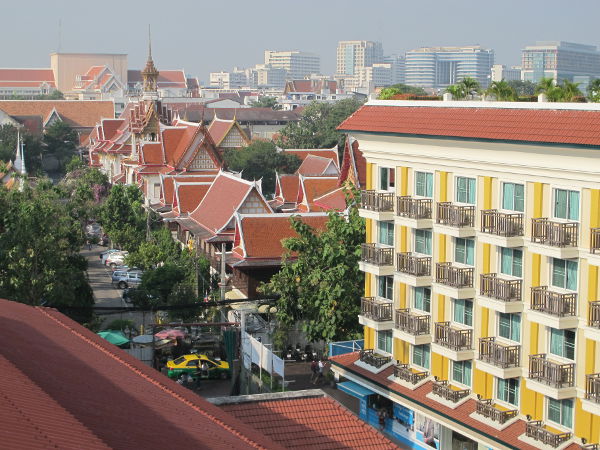 Näkymä toiselta uima-altaalla. Keltaisen talon katolla sijaitsee toinen uima-allas. Sen ja temppelirakennusten välissä kulkee Soi Rambutri. 