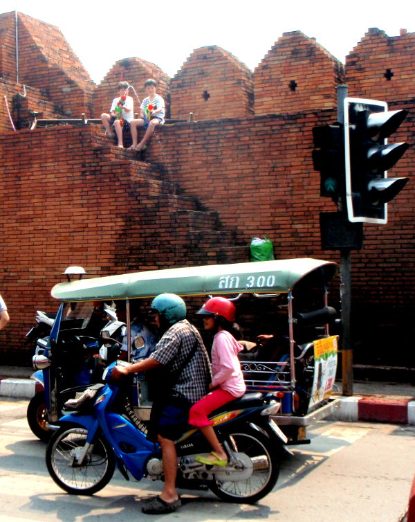 Pikkupojat ampumassa ohiajajia vanhan kaupungin muurilla. Songkranin aikaan tapahtuu moninkertaisesti liikenneonnettomuuksia muihin aikoihin verrattuna. 