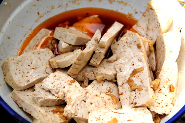 Tofut marinoitumassa valkosipulin, inkiväärin, soijakastikkeen, sitruunan ja paprikamausteen sekoituksessa. Punainen sävy tulee paprikasta.