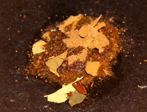 Paistinpannun keskellä on ruokaöljyä, johon lisäsin jotain intialaista maustesekoitusta kaapistani. Sekoituksessa on mukana jonkinlaisia laakerinlehden palasia.