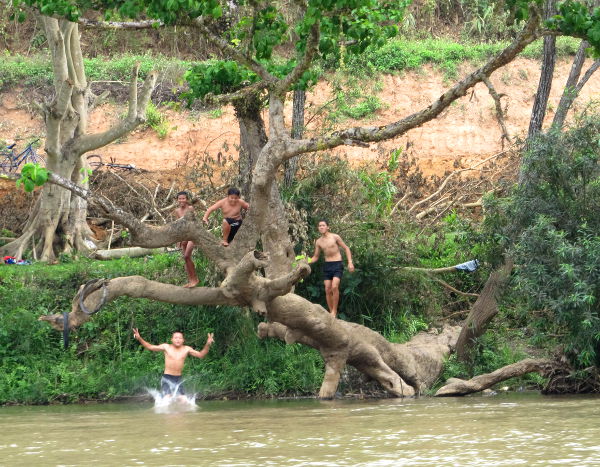 Poikia hyppimässä jokeen. 