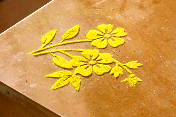 Joitain koristekuvioita tehdään hiekasta sapluunaa hyväksi käyttäen, mutta perinteisimmät tehdään ympyrämuotoon käsivaralla. 