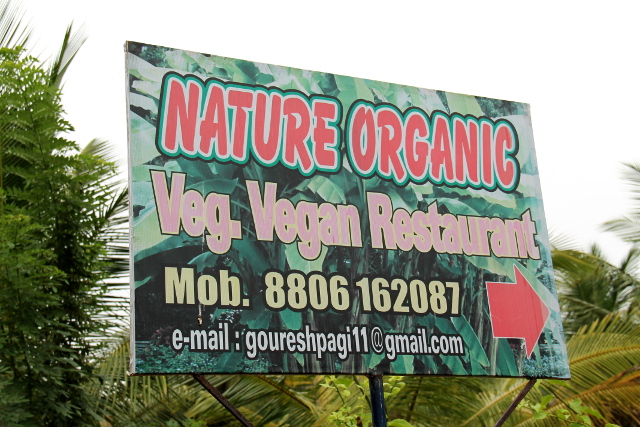 Kasvisravintolan kyltti kylänraitilla. 