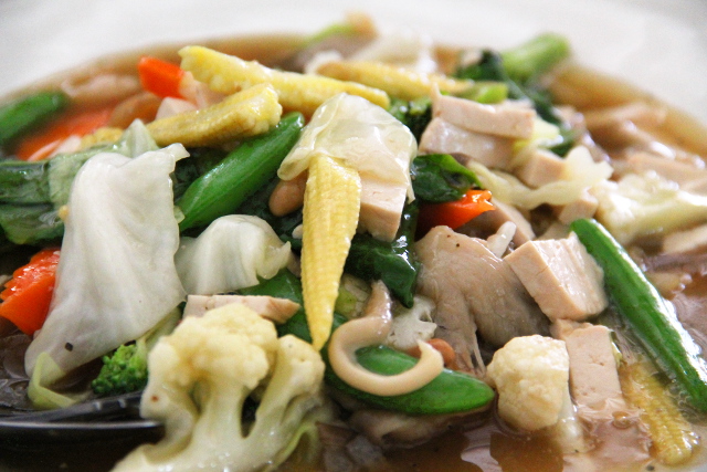 Paistettuja leveitä nuudeleita vihannesten kanssa. 