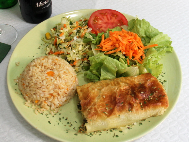 Pinaatti-tofupiirakkaa salaatein ja maustetuin riisein. 