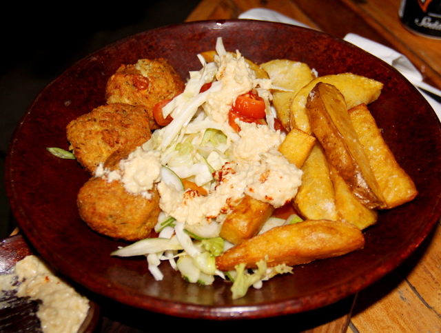 Ikanin falafellautanen, johon tuuppaistu hummukset falafelien, ranskisten ja salaatin päälle. 