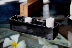 Kokoonpuristetut pyyhkeet. Toinen on kastettu vesitippaan ja siitä on tullut kostuessaan korkeampi. 