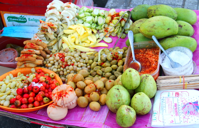 Erikoisen näköistä ruokaa Phnom Penhin kadulla. Kyse taitaa olla happaman makuisista raaoista mangoista ja pikkelöidyistä vihanneksista, jotka syödään chilitahnan kera. Tuollaisissa chilitahnoissa on useimmiten katkarapua ja kalakastiketta. 