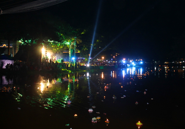 Vesifestivaalien valoja ja kelluvia kratongeja joessa. 