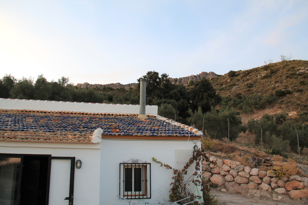 valkoiseksi rapattu matala talo vuoren rinteellä Espanjassa